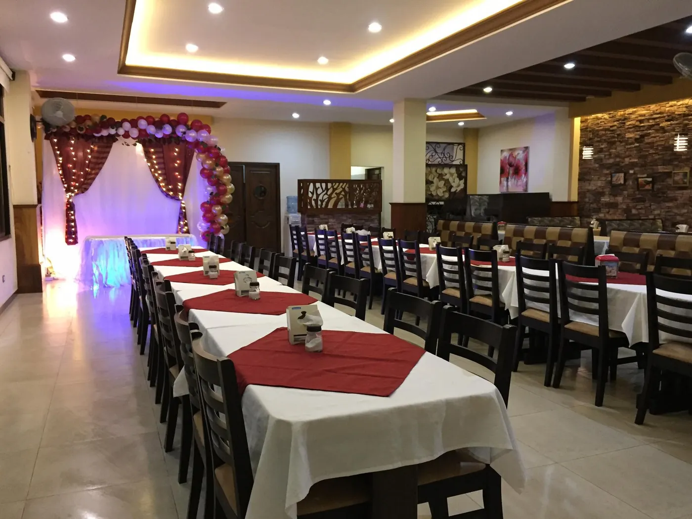 Mesa larga decorada para un cumpleaños con arco de globos
