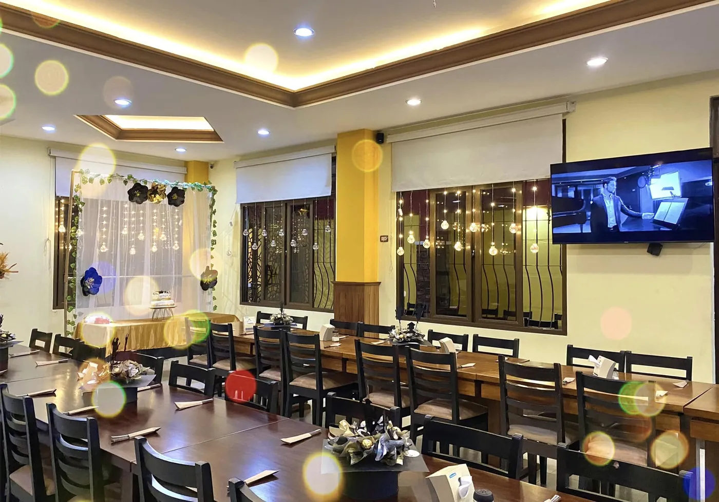Salón preparado para una reunión con centros de mesa y luces